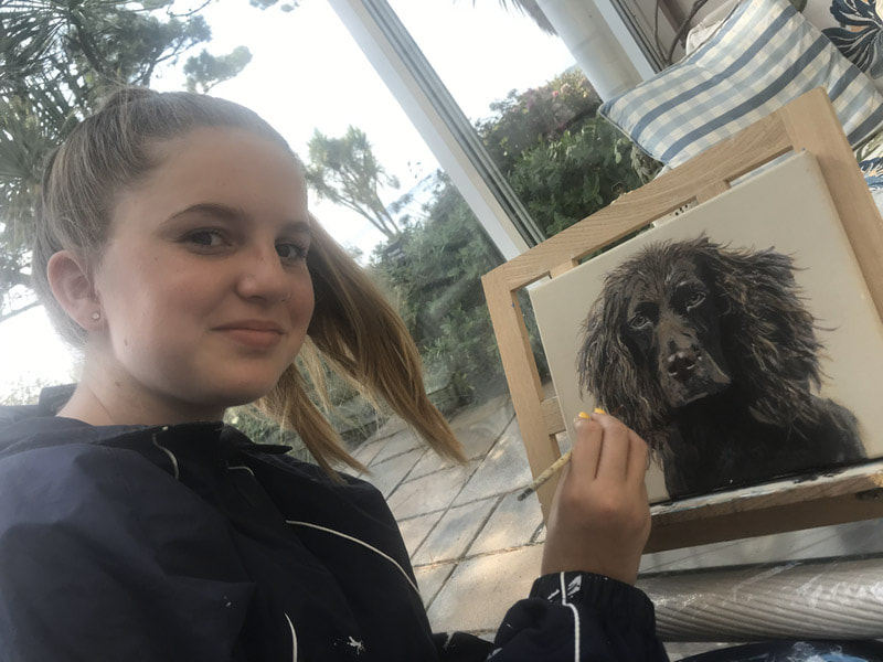 A student painting a dog during a lesson