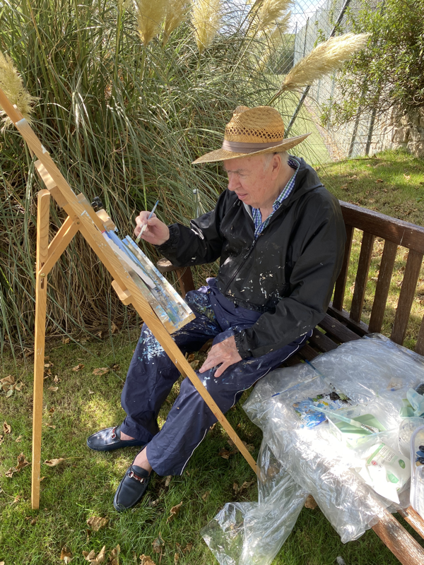 A gentleman painting at an easel with jeanni the  Nare Hotel's 'Artist in Residence', Cornwall