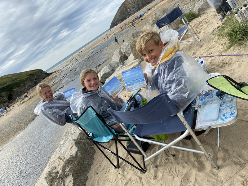 Family group doing an art lesson with jeanni on the beach