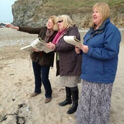 Picture of some ladies doing the  art perspective lesson wih jeanni whilst walking on one of Cornwall's most beautiful beaches. Perspective in action right before your eyes. 